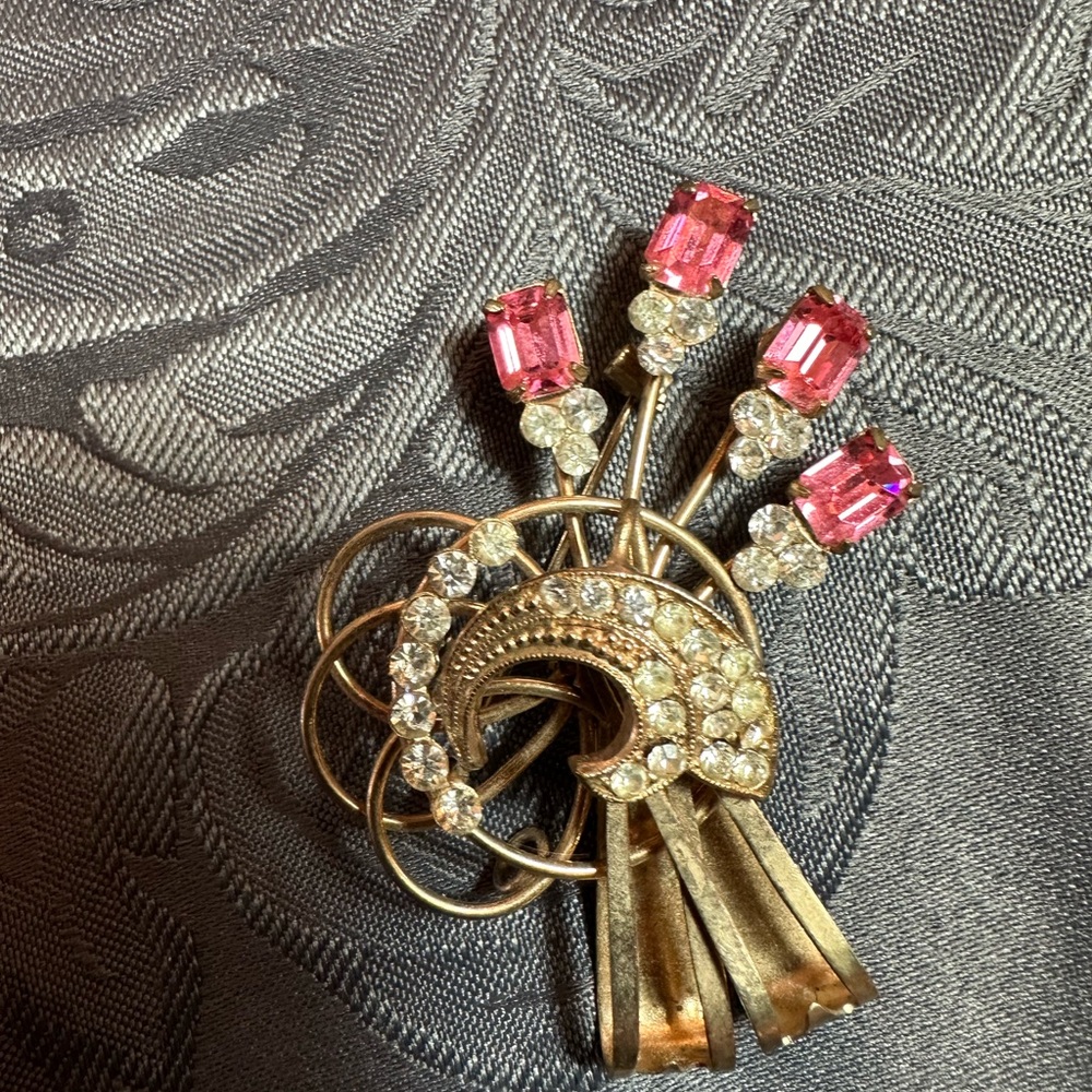 Gold brooch with pink and clear rhinestones.